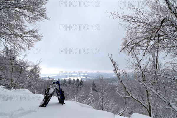 View from the mountain Moerschieder Burr in the Hunsrueck-Hochwald National Park of the snow-covered landscape with snowshoes in the foreground