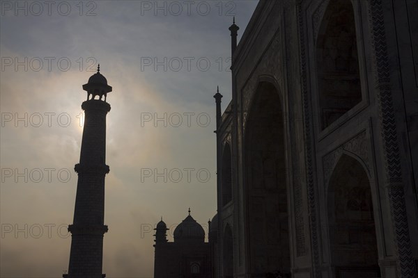 Taj Mahal at early morning with its minaret backlit by the rising sun