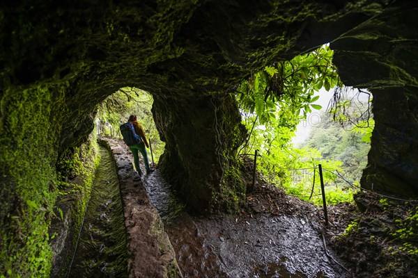 Hiker in a tunnel at PR9 Levada do Caldeirao Verde