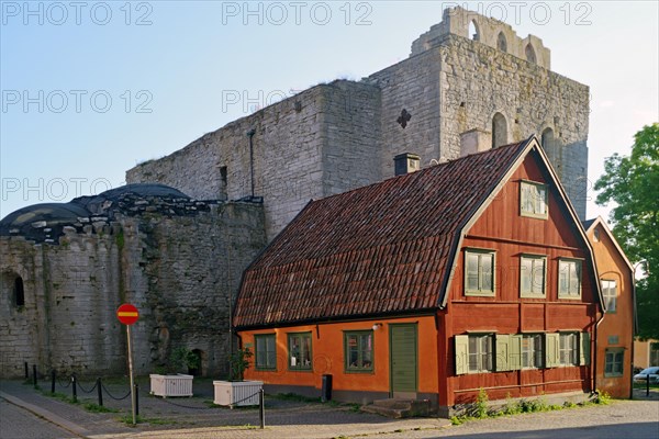 Small red house in front of medieval church ruin