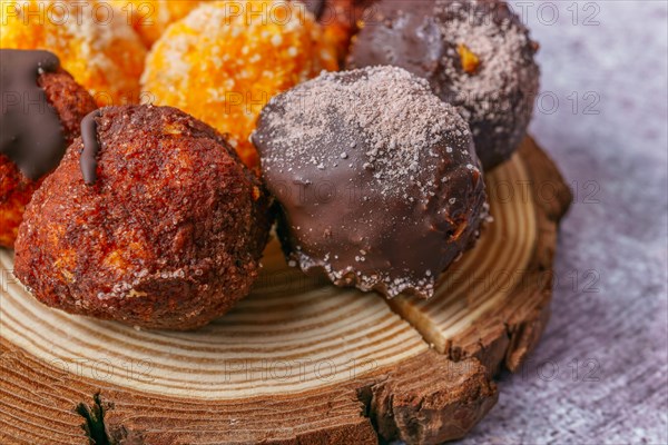 Close-up of sweet truffles of different flavors on a wooden disk