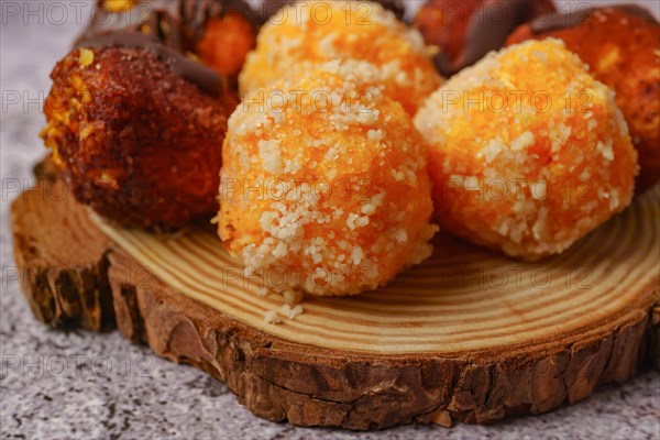 Close-up of sweet truffles of different flavors on a wooden disk