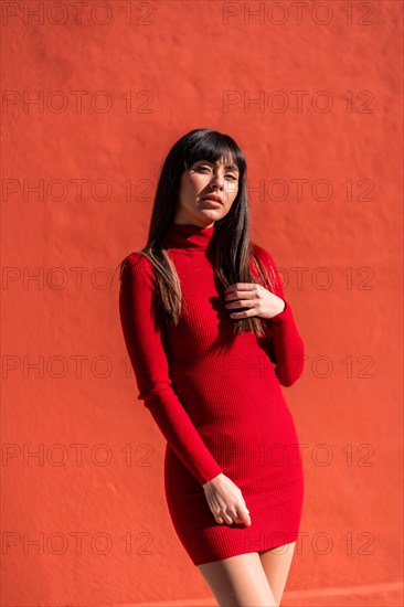 Posing brunette girl smiling in a dress and black leather boots in spring