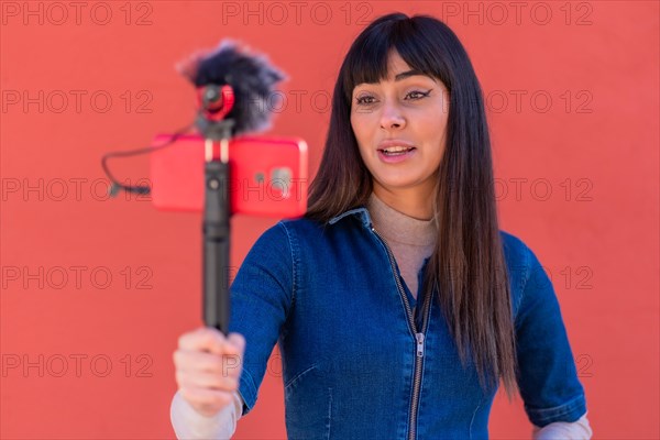 Brunette girl recording a vlog in a blue denim outfit