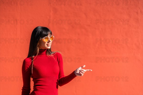 Brunette girl in a spring orange dress and sunglasses