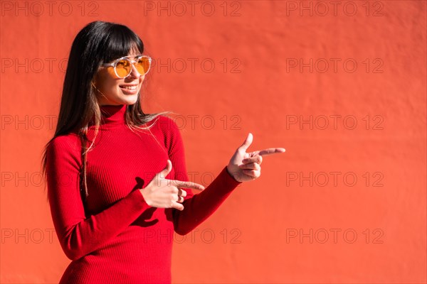 Brunette girl in a spring orange dress and sunglasses