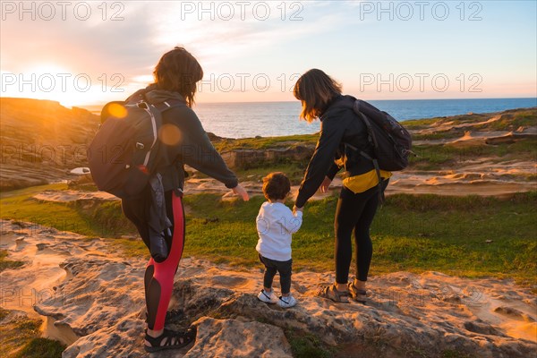 Two women with a child on the coast of Mount Jaizkibel next to San Sebastian