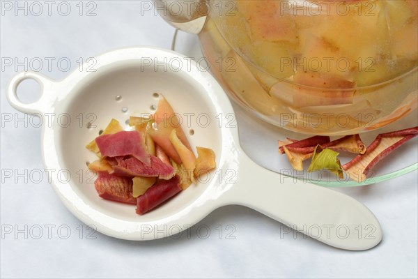 Apple peel tea in teapot and apple peel in tea strainer