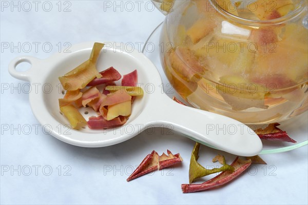 Apple peel tea in teapot and apple peel in tea strainer