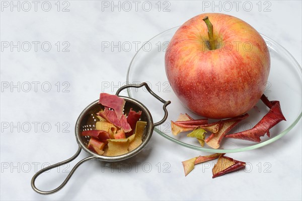 Apple peel tea in tea strainer and apple