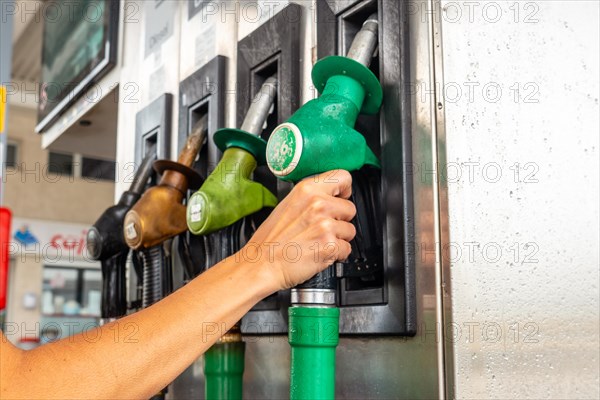 Womans hand at the automatic gasoline or diesel pump at the gas station