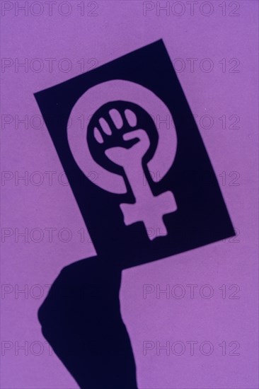 Shadow of the symbol of the fight for feminism on a purple background