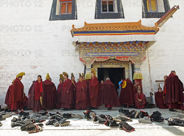 Yellow-capped monks and shoes at the prayer hall