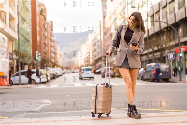 Portrait of tourist woman with suitcase on vacation in the city just arrived by plane