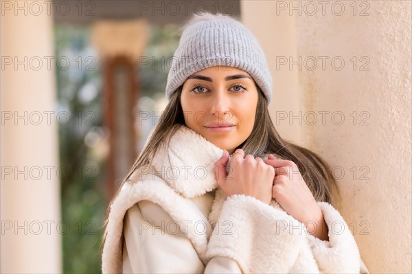 Portrait with woman in wool hat in a city park looking at camera