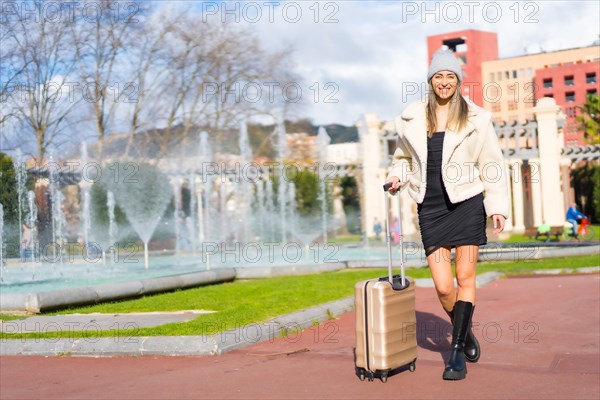 Portrait of a caucasian woman in a wool hat in a city park by a fountain