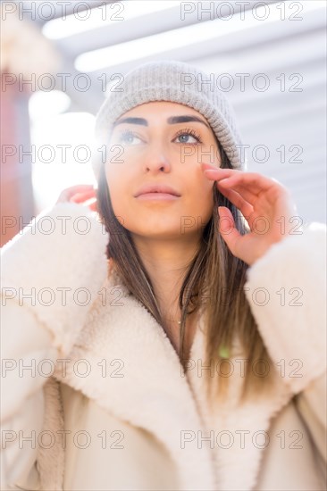 Portrait of caucasian woman with wool cap in a city park at sunset