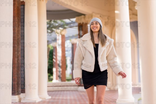 Woman with wool cap smiling visiting a city park