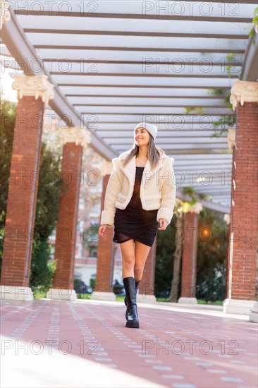 Pretty caucasian woman in a wool hat walking in a city park