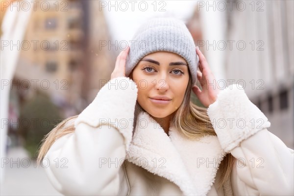 Winter portrait of a caucasian woman in a wool hat in the city