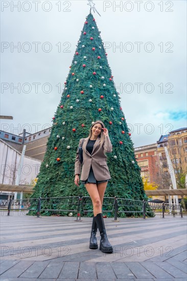 Portrait next to christmas tree in town city