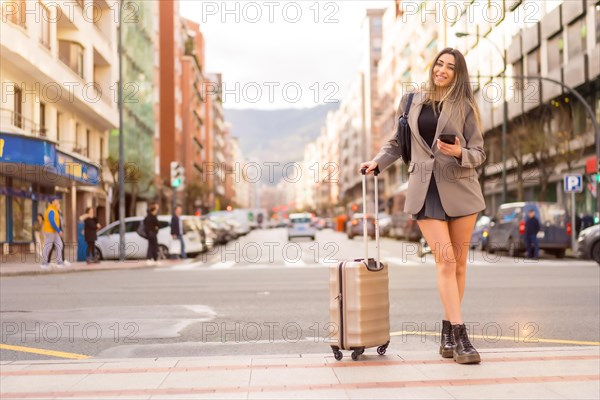 Portrait of tourist woman with suitcase on vacation in the city just arrived by plane