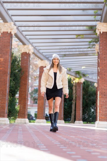 Pretty caucasian woman in a wool hat walking in a city park