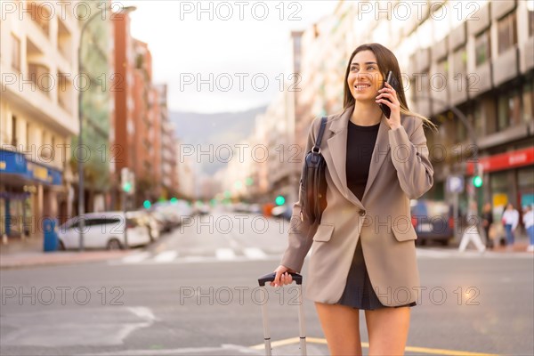 Tourist woman with suitcase in the city smiling