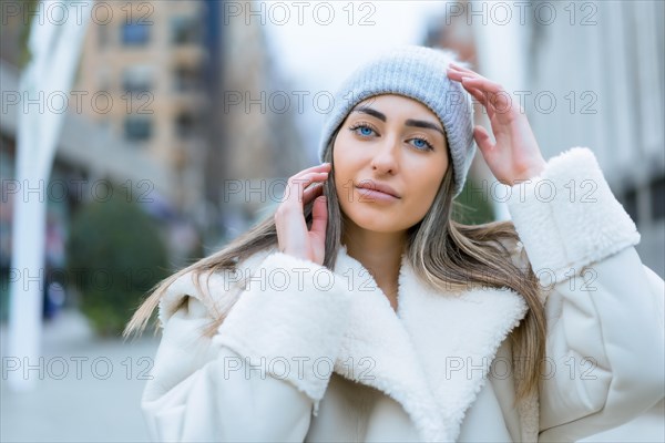 Winter portrait of a caucasian woman in a wool hat in the city