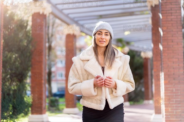 Pretty caucasian woman with wool hat in a city park