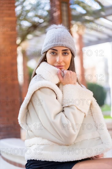 Caucasian woman in a wool hat sitting in a city park