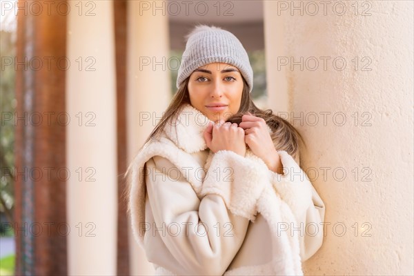 Portrait with woman in wool hat in a city park looking at camera