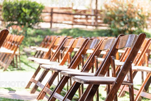 Rows of wooden event chairs at wedding venue abstract