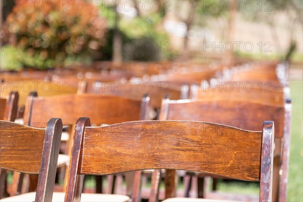 Rows of wooden event chairs at wedding venue abstract