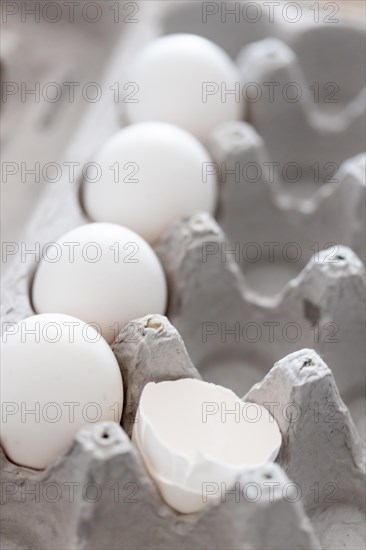 Carton of white chicken eggs and egg shells