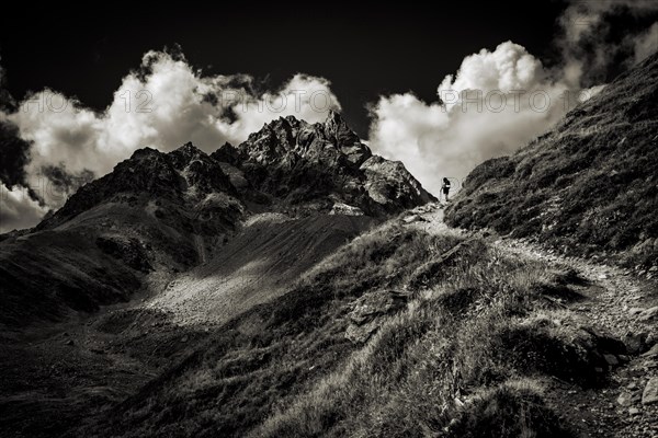 Mountain path with climber in the background Peak of Piz Kesch