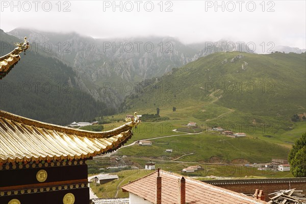 Golden temple roofs and green valleys in the mountain landscape