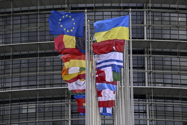 Ukrainian and EU flag in the wind in front of the European Parliament