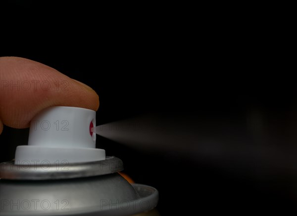 Finger pressing a spray can with white background and copy space