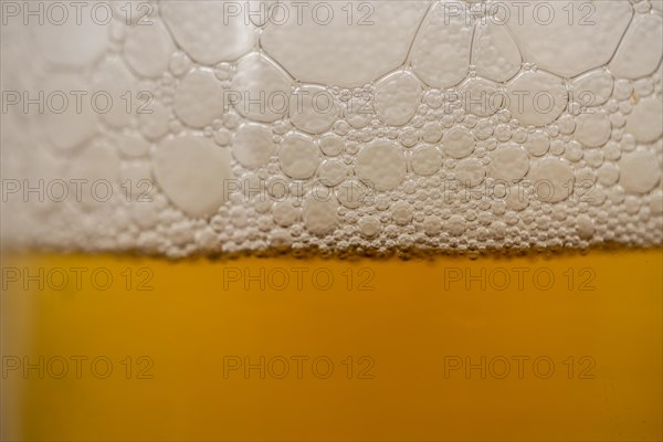 Close-up of beer foam with bubbles with selective focus