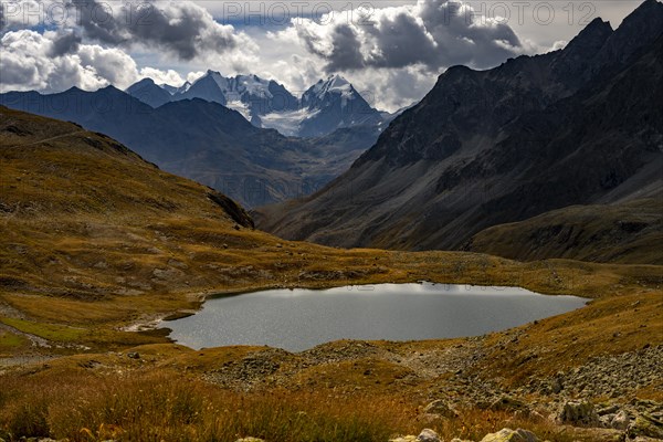 Mountain lake Lej Suvretta with Bernina group and Engadine mountains with cloudy sky