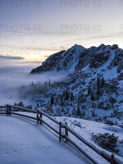 Mountain slope with snow at sunrise with clouds and clear sky and high fog