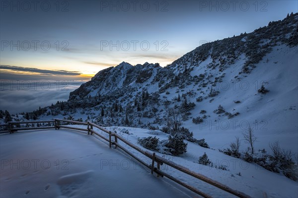 Mountain slope with snow at sunrise with clouds and clear sky and high fog