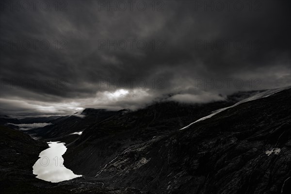 Mountain lake Lej da Vadrett with Val Rosegg and dramatic clouds