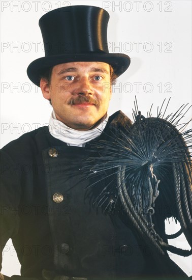 Chimney sweep in professional training and posing in a photo studio