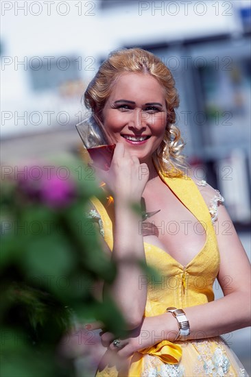 Portrait of a woman in dirndl with a glass of sparkling wine in her hand