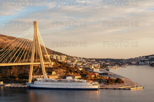 Sunset over Dubrovnik with bridge and cruise ship