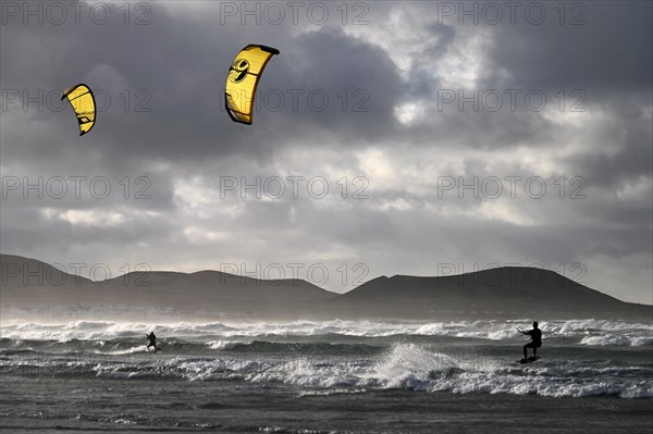 Kitesurfers at sunset on the beach of Caleta de Famara