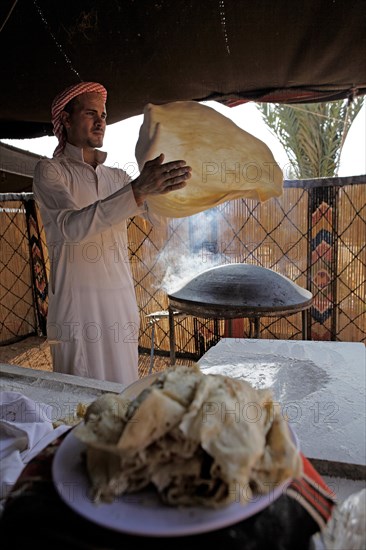 Jordanian man baking traditional Bedouin flatbread
