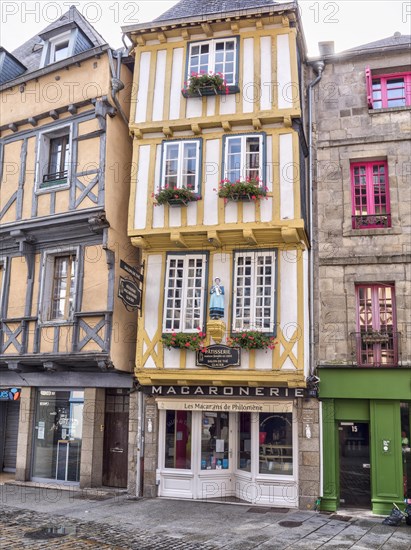 Narrow half-timbered house with statue of a woman in historical traditional costume in the Rue Kereon